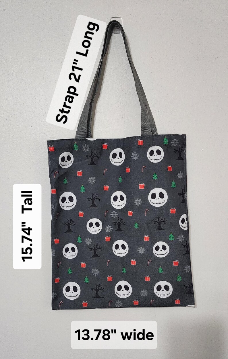 May include: A black tote bag with a repeating pattern of Jack Skellington faces, Christmas trees, snowflakes, and gift boxes. The bag is 15.74" tall and 13.78" wide, with a 21" long strap.