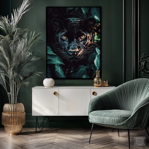May include: A framed art print featuring a black panther's face peering out from lush green foliage. The artwork is displayed above a white cabinet with gold hardware, complemented by a gold vase and a green velvet armchair. The room has dark green walls.