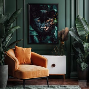 May include: A framed art print featuring a black panther peering out from lush green foliage. The panther's yellow eyes are visible. The artwork hangs above an orange armchair and a white cabinet with a wooden handle. The room has dark green walls.