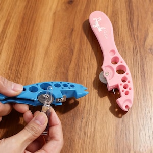 May include: A blue and a pink ampoule opener. The blue opener is in use, holding a glass ampoule. The pink opener has the name "Angela" printed on it. Both openers have a wheel and a pin.