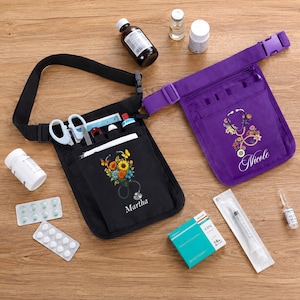 May include: A black and a purple nurse utility belt organiser, each featuring a floral stethoscope graphic and a name printed in white. The black organiser is labelled Martha, and the purple one is labelled Nicole. Both include multiple pockets.
