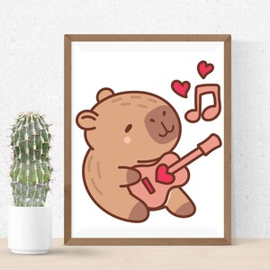 May include: A framed print featuring a cartoon bear playing a pink guitar with a heart-shaped sound hole. Two red hearts and a musical note are above the bear. The bear is light brown with a darker brown outline.