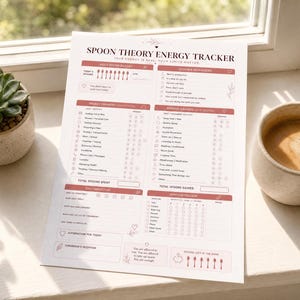May include: A white paper sheet titled Spoon Theory Energy Tracker with sections for daily spoon budget, energy drains, energy gainers, daily reflection, and symptom tracking. The layout features pink headers, icons, and text lists for daily tasks.