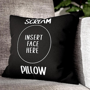 May include: Black pillow with white text that reads "Scream" and "Insert Face Here" in a circle. Below the circle is the word "Pillow".
