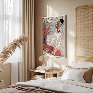 May include: A framed art print depicts a person in white clothing and red pants, seated in a meditative pose. The artwork features a serene scene with floral elements and a soft color palette, suitable for home decor.