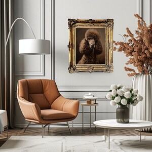 Product image of A brown poodle in a gold ornate frame, hanging on a white wall with a brown leather armchair and a white table in the foreground.