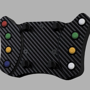 Può includere: Un volante da corsa in fibra di carbonio con più pulsanti colorati. Il volante ha una base nera con un motivo in fibra di carbonio strutturato. I pulsanti sono rossi, verdi, gialli, blu e bianchi.