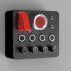 May include: A black control panel with a carbon fiber texture. It features a red start button with white text, toggle switches, and rotary dials. A red safety cover is on the left side.