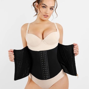 Puede incluir: Faja de cintura negra con cremallera y cierre de gancho y ojo. La faja de cintura tiene una fila de ganchos y ojales en la parte delantera y una cremallera que sube por la parte delantera. La faja de cintura está hecha de un material elástico.