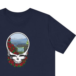 May include: A navy blue t-shirt with a graphic of a smiling skull with a view of a bridge and the words "Rose Garden" on a sign inside the skull.