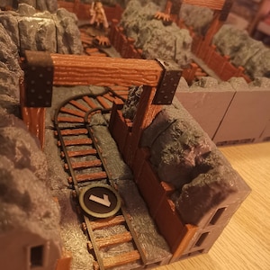 Könnte beinhalten: Ein Miniaturmodell einer Eisenbahnstrecke mit einer Holzbrücke und einer grauen Felswand. Die Strecke hat die Nummer "7" auf einem runden Schild.