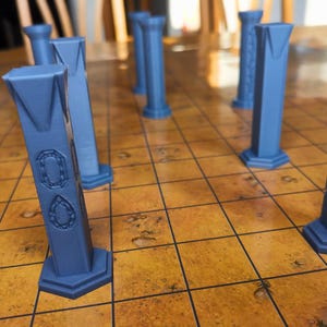 Könnte beinhalten: Ein Satz blauer Spielsteine aus Kunststoff in Form von Säulen. Die Steine sind auf einem braunen und schwarzen Schachbrett angeordnet.