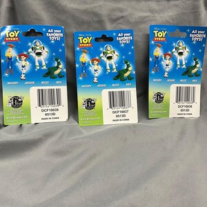 K&ouml;nnte beinhalten: Drei Toy Story Charakter-Sammelkarten mit Woody, Jessie, Buzz Lightyear und Rex. Die Karten sind blau, gr&uuml;n und rot mit dem Text "All your favorite toys!" und "Toy Story".