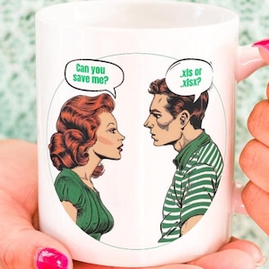 May include: White ceramic mug with a comic book style illustration of a man and woman. The woman is saying "Can you save me?" and the man is saying ".xis or .xisx?"