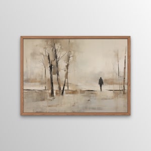以下が含まれることがあります： 霧のかかった森の風景を描いた額装された絵画。一人の人物が鑑賞者から遠ざかって歩いています。絵画は、茶色、灰色、白の落ち着いた色調で描かれています。
