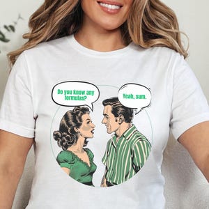 May include: White t-shirt with a retro comic-style illustration of a couple. The woman asks "Do you know any formulas?" and the man replies "Yeah, sum."