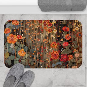 May include: Rectangular bath mat with a floral design in shades of orange, red, and brown. The flowers and leaves are stylized with a vintage art deco aesthetic. The mat is placed on a tiled floor, with a pair of gray slippers visible.