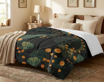 May include: A dark comforter with a botanical design featuring green leaves and orange circular shapes. The comforter is on a bed with beige pillows and a beige throw blanket. The bed is in a well-lit room.