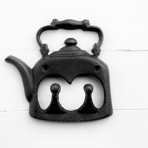 May include: Black cast iron teapot shaped wall hook with two hooks on the bottom.