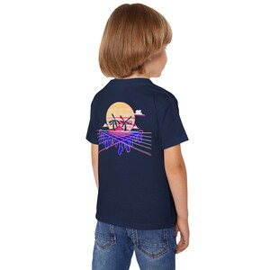 May include: Navy blue t-shirt featuring a retro sunset design with palm trees, a sun, and dripping lines in shades of orange, pink, and blue. The graphic is on the back of the shirt. The shirt is made of a soft material.