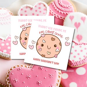 Può includere: Due biglietti di San Valentino stampabili con un simpatico biscotto con un viso sorridente e il testo "Grazie per avermi fatto un biscotto intelligente" e "Buon San Valentino!"