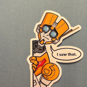 Puede incluir: Una pegatina de dibujos animados de un robot amarillo y blanco asomándose por una esquina con un globo de diálogo que dice "Lo vi."