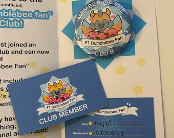 May include: A blue and yellow membership card for the "#1 Bumblebee Fan" club. The card features a cartoon image of Bumblebee, a yellow robot character, with the text "#1 Bumblebee Fan Club Member" printed on it. The card also has a handwritten name, "Happi", and membership number, "000001". The text "Don't forget to sign your name!" is printed below the card.