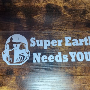 May include: White vinyl sticker with a helmet graphic and the text "Super Earth Needs You!"