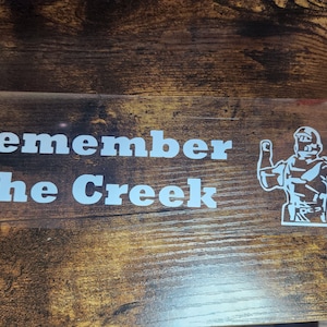May include: White vinyl sticker with the text "Remember The Creek" and a silhouette of a person with their arm raised.
