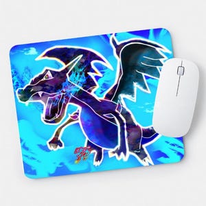 May include: A rectangular mousepad featuring a blue and purple dragon graphic with a white outline, set against a bright blue background. A white computer mouse is positioned to the right of the mousepad. The dragon has its mouth open.