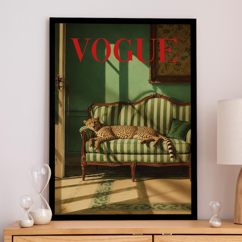 K&ouml;nnte beinhalten: Ein gerahmter Kunstdruck, der einen Geparden zeigt, der auf einem gr&uuml;n-wei&szlig; gestreiften Sofa in einem Raum mit gr&uuml;nen W&auml;nden ruht. Das Wort VOGUE ist in gro&szlig;en roten Gro&szlig;buchstaben oben aufgedruckt. Die Szene umfasst eine T&uuml;r und ein Bild.