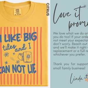 May include: A citrus yellow t-shirt featuring a graphic with vertical orange stripes and the blue text I LIKE BIG tiles and I CAN NOT LIE, accompanied by illustrations of mahjong tiles and small floral accents, with a Comfort Colors brand label.