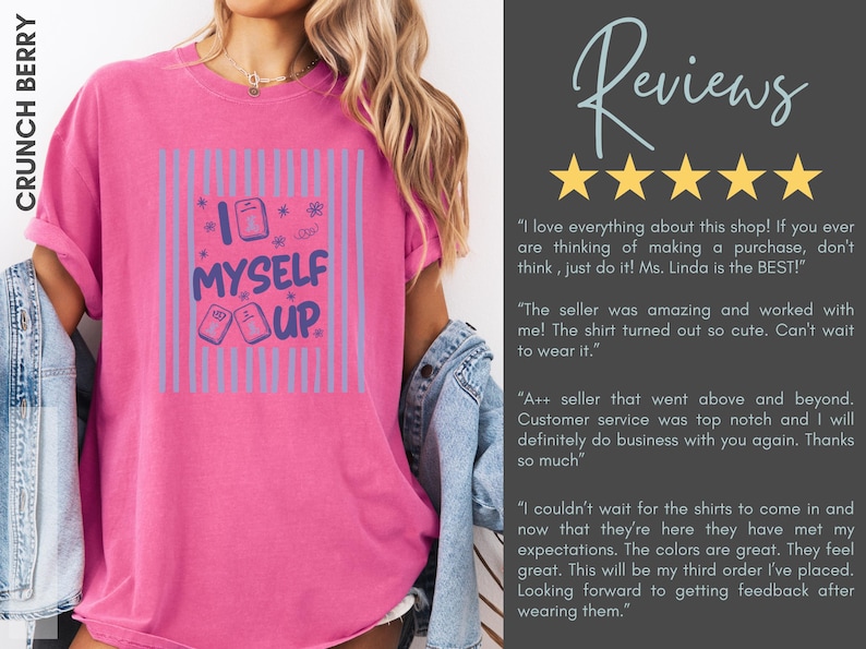 May include: A bright pink t-shirt featuring a graphic design with vertical light blue stripes and the text "I MYSELF UP" in dark blue lettering. The design includes small rectangular icons and star shapes. The shirt has a crew neckline and short sleeves.