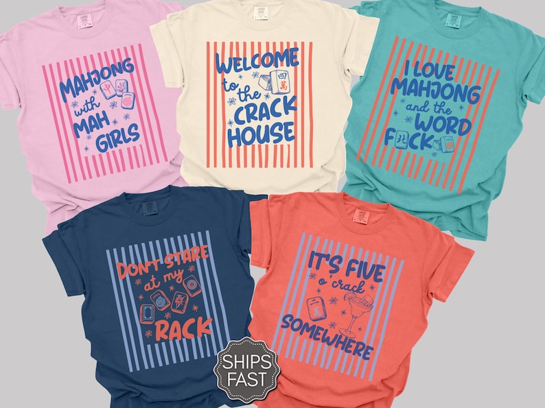 May include: Five short-sleeved crew neck t-shirts in pink, cream, teal, navy, and coral. Each shirt features a central graphic with vertical stripes and text related to mahjong, including phrases like Mahjong with Mah Girls and It's Five o'crack Somewhere.