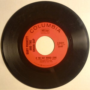 May include: A red and white vinyl record with the text "COLUMBIA" in a white circle with a red border. The record is labeled with the text "GARY PUCKETT AND THE UNION GAP" and the song title "IF THE DAY WOULD COME". The record label also includes the songwriters, arranger, producer, and the record number "4-44644".