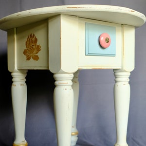 Vintage-Inspired White Accent Table: Floral Details, Drawer, Turned Legs