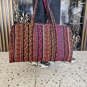 Close-up of the vibrant handwoven patterns on the Gaziantep rag suitcase, showcasing traditional Turkish designs.