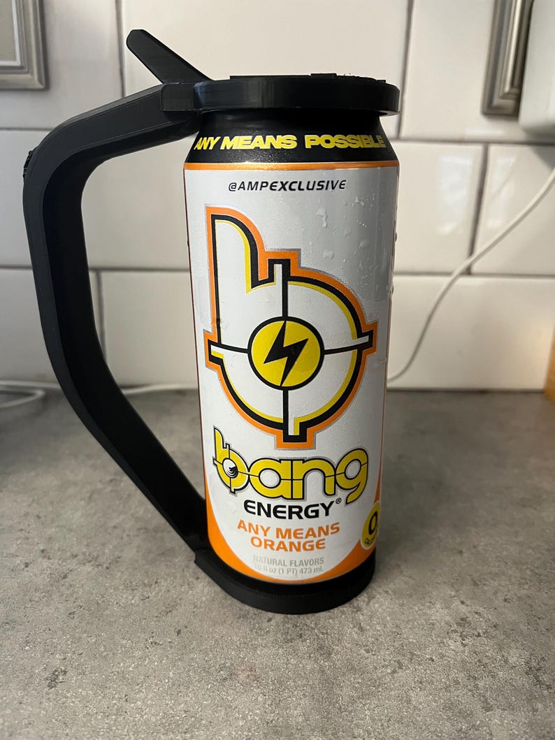 May include: A can of Bang Energy drink with a black handle attached. The can is white with orange and yellow graphics, including the text "ANY MEANS POSSIBLE" and "ANY MEANS ORANGE". The can contains 16 fl oz (473 ml) of liquid.