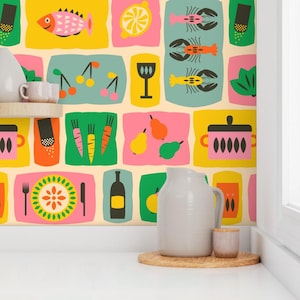 May include: Colorful wallpaper featuring food illustrations, including a fish, cherries, pears, and a pot. The design incorporates various shapes and colors, creating a vibrant and playful aesthetic. A white pitcher and small cup sit on a wooden tray.