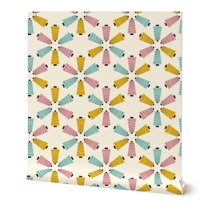May include: Wallpaper roll featuring a repeating pattern of stylized spools of thread. The spools are arranged in a floral design, with alternating colors of yellow, pink, and blue on a cream background. The spools have black accents and horizontal stripes.