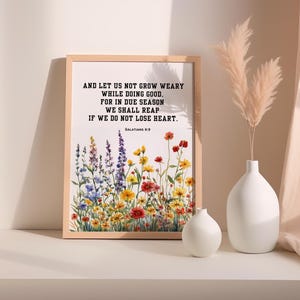 May include: A framed print with a watercolor painting of a field of wildflowers. The print features a bible verse from Galatians 6:9, "And let us not grow weary while doing good, for in due season we shall reap if we do not lose heart."