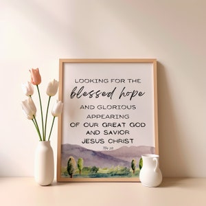 May include: A framed print with a watercolor background of a landscape with trees and a quote that reads "Looking for the blessed hope and glorious appearing of our great God and Savior Jesus Christ Titus 2:13"