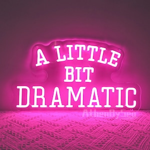 Puede incluir: Letrero de neón rosa con letras blancas que dice "A Little Bit Dramatic".