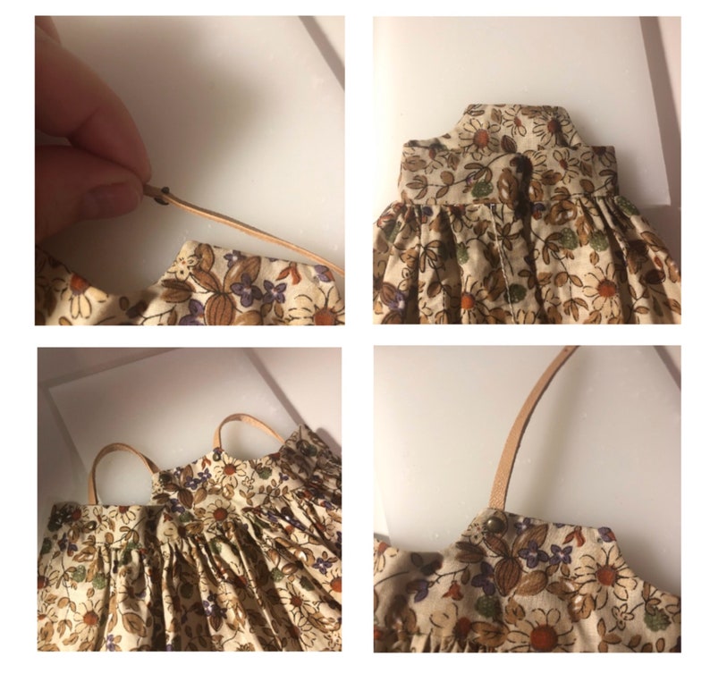 May include: A miniature floral print dress with tan straps. The dress features a beige background with brown, purple, and green floral patterns. The straps are a light brown color. The dress is likely for a doll or small figurine.