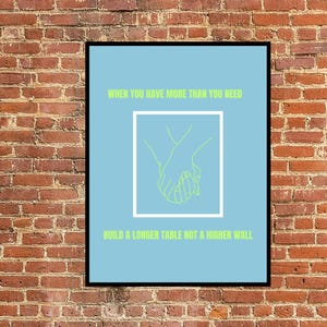 May include: A light blue poster with a green outline of two hands holding each other. The text on the poster reads "WHEN YOU HAVE MORE THAN YOU NEED BUILD A LONGER TABLE NOT A HIGHER WALL."