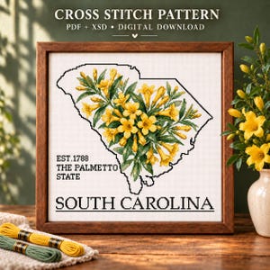 May include: A cross stitch pattern digital download featuring the outline of South Carolina filled with yellow jasmine flowers. The text reads EST. 1788 THE PALMETTO STATE and SOUTH CAROLINA. The design is displayed in a wooden frame on a table.