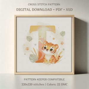 May include: A framed cross-stitch pattern featuring a watercolor illustration of a tiger cub and the letter "T". The design includes leaves and paw prints in soft colors. The text at the top reads "CROSS STITCH PATTERN" and "DIGITAL DOWNLOAD".