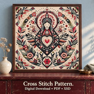May include: A framed cross stitch pattern featuring a central figure with a heart, surrounded by symmetrical floral and geometric motifs in red, black, and muted green on a cream background. The text reads Cross Stitch Pattern. Digital Download • PDF • XSD.