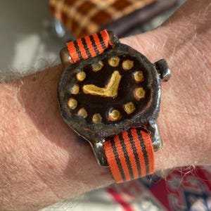 May include: A white ceramic mug with a black handle and the text "But First, Coffee" in a bold, black font. The mug is set against a neutral background, highlighting its simple design.