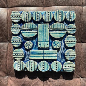 May include: A white ceramic mug with a black handle and the text "But First, Coffee" in a bold, black font. The mug is set against a neutral background, highlighting its simple design.